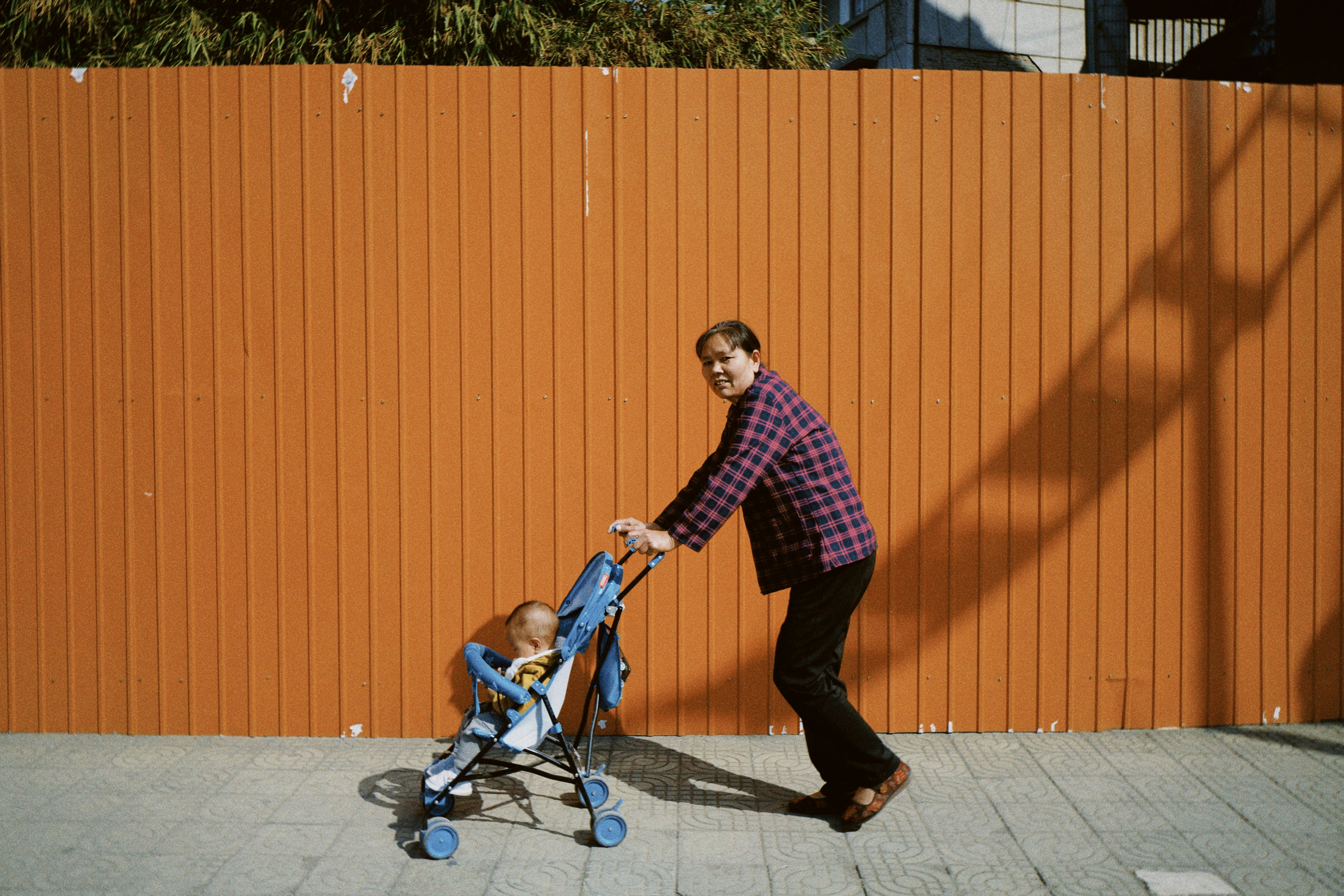 man in red and white plaid dress shirt and black pants riding blue and black kick